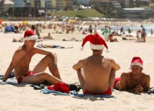 SYDNEY, NSW - DECEMBER 25: Crowds relax and soak up the sunshine wearing santa hats at Bondi Beach on Christmas Day December 25, 2005 in Sydney, Australia. (Photo by Cameron Spencer/Getty Images)