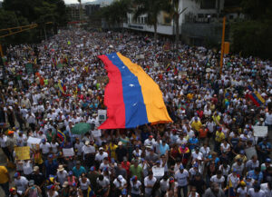 CARACAS, VENEZUELA - MARCH 02: Carrying a giant Venezuelan flag, thousands of anti-government protesters march during a mass demonstraiton on March 2, 2014 in Caracas, Venezuela. Venezuela has one of the highest inflation rates in the world, and opposition supporters have protested for almost three weeks, virtually paralyzing business in much of the country. (Photo by John Moore/Getty Images)