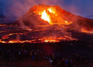 REYKJANES PENINSULA, ICELAND - MARCH 28: People's figures are illuminated by the glow of the lava on March 28, 2021 on the Reykjanes Peninsula, Iceland. The Mount Fagradalsfjall volcano erupted on March 19, after thousands of small earthquakes in the area over the recent weeks, and was reportedly the first eruption of its kind on the Reykjanes Peninsula in around 800 years. (Photo by Sophia Groves/Getty Images)